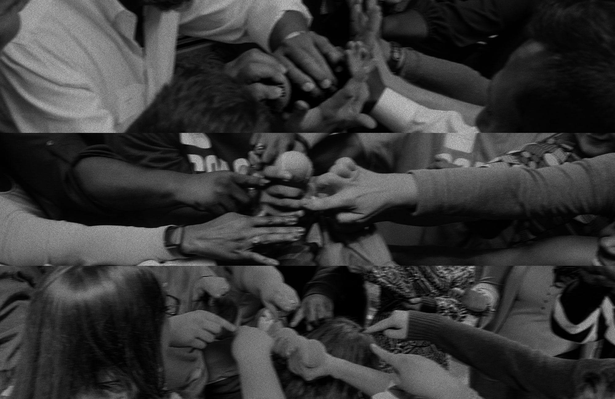 black and white photo of hands reaching towards center